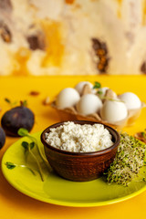 Ricotta cheese, 6 white eggs, figs, micro green and almond on yellow background