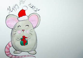 Girl sitting draws with watercolors on a white sheet of paper a mouse with a green gift. Top view. New Year 2020, the year of the mouse