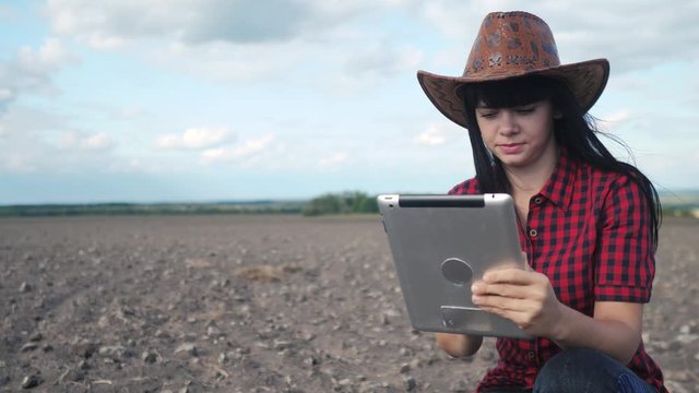 smart eco a harvesting agriculture farming concept. girl farmer with digital tablet lifestyle studies the earth dirt in the field of agriculture . woman farmer works in agriculture field