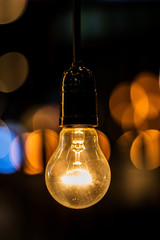 Old light bulb glowing in dark. vintage filter