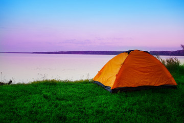 Tourist tent on shore of calm lake in early morning © alexlukin