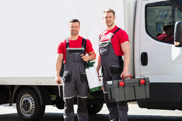 Portrait Of A Smiling Young Male Technicians Holding Tool Box