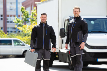 Portrait Of Two Male Electrician Carrying Tool Boxes - obrazy, fototapety, plakaty