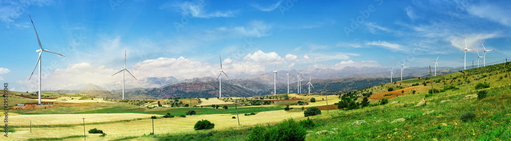 Wall mural wind turbine generators stand in row on green field