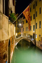 Fototapeta na wymiar View of the city narrow street, canal with bridge in Venice at night