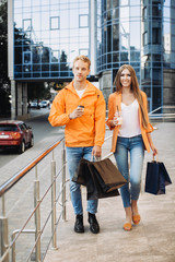 Happy friends walking with bags after Black Friday shopping