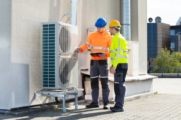 An Electrician Men Checking Air Conditioning Unit