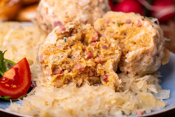 two speckknoedel with sauerkraut on wood
