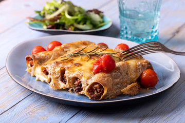 six italian canneloni pasta rolls on wood
