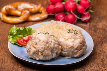 two speckknoedel with sauerkraut on wood