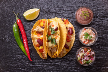 three mexican tacos on slate