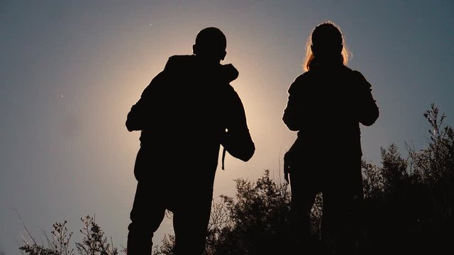 teamwork tourists travel concept slow motion video. hiking silhouette happy family couple man and girl go hiking climbing a mountain. walking on nature. tourists with backpacks lifestyle traveling