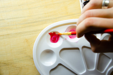 White palette for mixing watercolor paints. Watercolor paints and brushes for painting. Artist set, bright colors