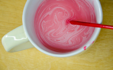 Red brush for painting in a glass with a capacity of water. Cleaning the brush from acrylic paint.