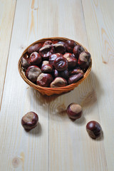 chestnuts in wicker cup on wooden background