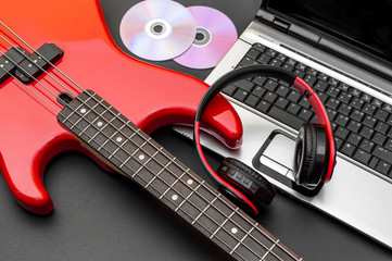 Electric guitar with laptop and headphones on black. Writing music.