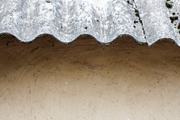 Closeup of old slate roof over a clay wall