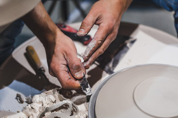 Potter in the pottery wheel in the workshop. Craft Ceramist.