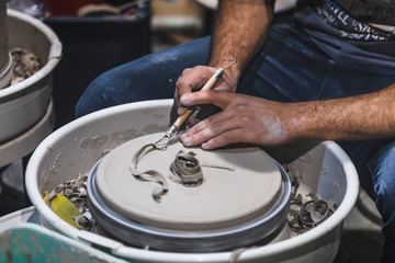 Potter in the pottery wheel in the workshop. Craft Ceramist.