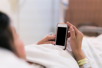 Patien using smartphone or tablet working hard from hospital ward