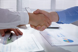 Businessmen Shake Hands With Each Other At Workplace