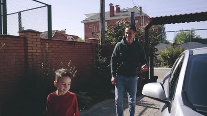 The father and son getting out of the car. slow motion