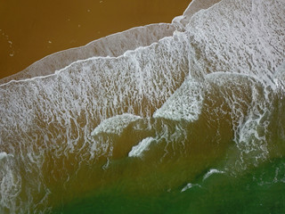 Aerial view of a wide sandy beach with large arriving and breaking ocean waves in Bay of Biscay France