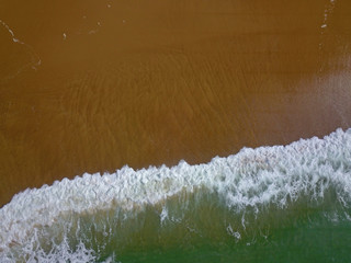 Aerial view of a wide sandy beach with large arriving and breaking ocean waves in Bay of Biscay France