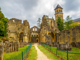 Fototapeta premium Orval Abbey Ruins next to the new Trappist Cistercian Orval Abbey, Abbaye Notre-Dame d'Orval in Villers-devant-Orval, Province of Luxembourg, Belgium