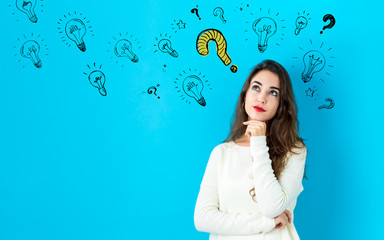 Fototapeta premium Question with light bulbs with young woman in a thoughtful face