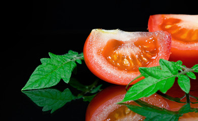 Fresh tomato on black background