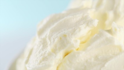 Mascarpone cream cheese closeup. Mascarpone soft milk cream rotated on blue background. Homemade ice cream, yoghurt. Slow motion 4K UHD video footage. 3840X2160