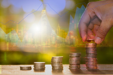 Double exposure hand put money coins on investment trading background