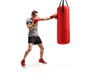 Man punching a bag with boxing gloves