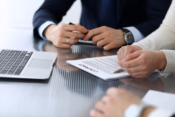 Obraz premium Business people discussing contract working together at meeting at the glass desk in modern office. Unknown businessman and woman with colleagues or lawyers at negotiation. Teamwork and partnership