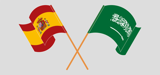 Crossed and waving flags of the Kingdom of Saudi Arabia and Spain