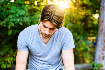 Portrait of model looking down with nice hair, concept of sadness in men, added film grain and...