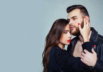 Touch his bristle. Passionate hug. Passionate couple in love. Man brutal well groomed macho and attractive girl cuddling. Girlfriend passionate red lips and man leather jacket. She adores male beard