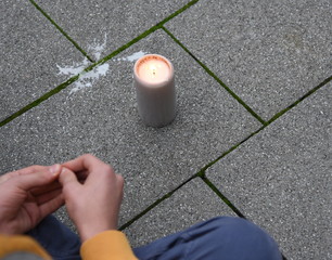 Trauernder hinter einer Kerze für die Opfer des Anschlags von Halle