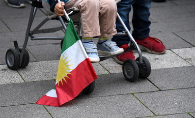 Kleinkind auf einer Demo mit kurdischer Flagge in der Hand