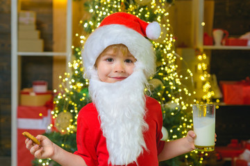Fototapeta na wymiar Funny child Christmas. Santa Claus. Milk and cookies for Santa Claus. Christmas for kid. Portrait of bearded funny child in Santa costume. Christmas Beard style.
