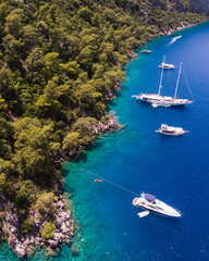 Aerial drone perspective of luxury Turkish gulets and yachts in the deep blue and turquoise waters...