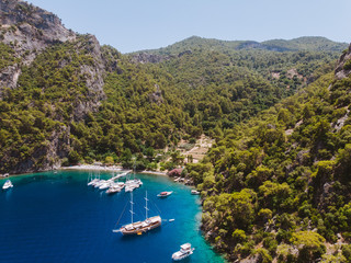 Aerial drone perspective of luxury Turkish gulets and yachts in the deep blue and turquoise waters...