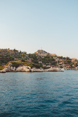 Obraz premium The village of Kalekoy seen south from a drone aerial perspective, with the Byzantine Simena castle in the centre near Kekova island in the Antalya Province of Turkey. Turkish flag flying at the top