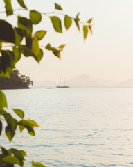 A lone traditional gulet sailing near Fethiye, Turkey. The mountainous coastal landscape can be seen in the distant background. 