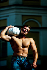 Halloween face art. Half face portrait. Sport and health food, Halloween gourd. Strong man body....