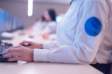 Fototapeta premium Security guard monitoring modern CCTV cameras in surveillance room. Female security guard in surveillance room.