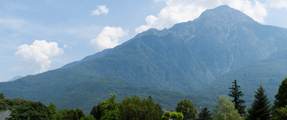 Fantastic view of mountains and forest on a sunny summer day. District of Como Lake, Colico, Italy, Europe. Panoramic view