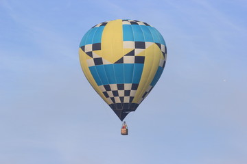 Obraz premium Hot air balloon floating on the blue sky, Colorful with yellow, blue, back and white.
