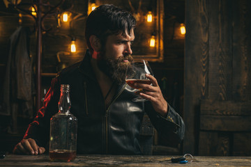 Man with beard holds glass brandy. Do not drink and drive